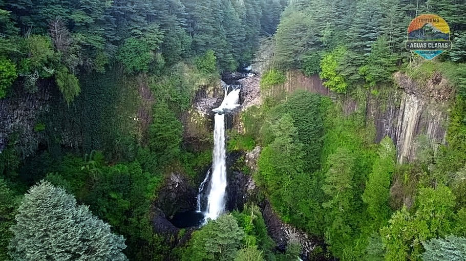 Vista aérea de la cascada Garganta del Brujo cayendo entre columnas basálticas, Cunco