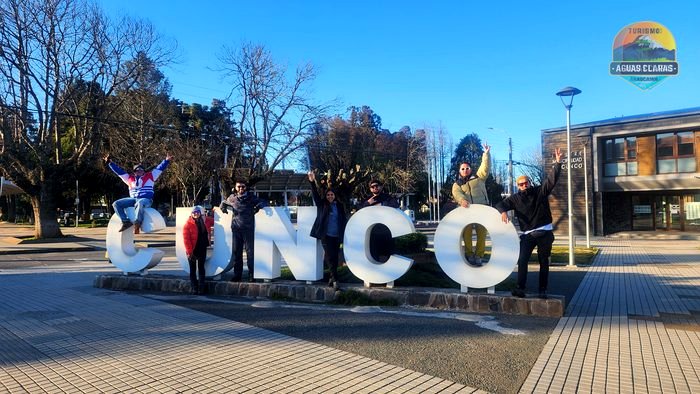 Grupo de pasajeros en el letrero de Cunco antes de partir rumbo al Geoparque